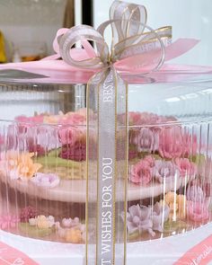 a close up of a cake in a glass container with a ribbon on it's side