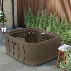 an outdoor hot tub sitting on top of a patio next to a wooden chair and potted plants