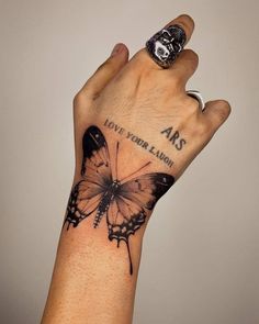 a hand with a butterfly tattoo on it and the words, love your salvation written in black ink