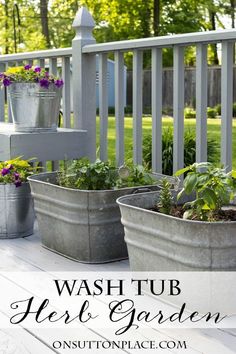 three metal planters sitting on top of a wooden deck