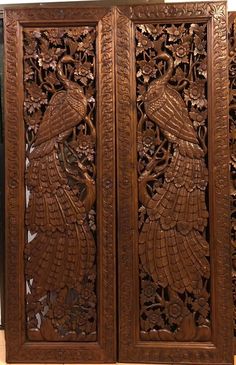 an intricately carved wooden screen with two peacocks on the front and one bird on the back