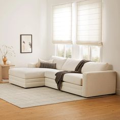 a living room with white furniture and wooden floors