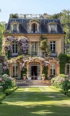 a large house with lots of flowers growing on it