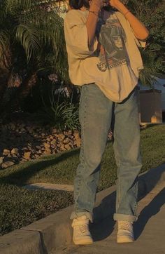 a man standing on the sidewalk taking a photo with his cell phone