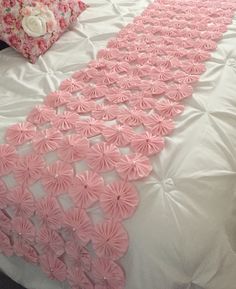 a bed with pink and white decorations on it