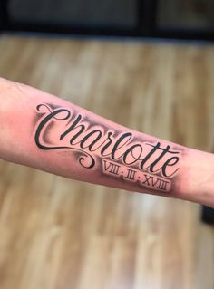 a man's arm with the word charlotte tattooed on it