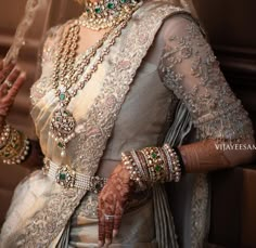 a woman in a bridal outfit with jewelry on her hands