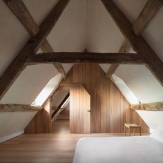 an attic bedroom with wood paneling and white walls