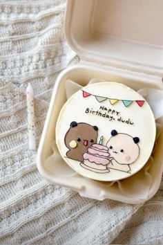 a birthday cake with two bears on it in a plastic container next to a toothbrush