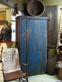 an old blue cabinet in a room with other items on the floor and furniture around it