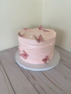 a pink cake sitting on top of a wooden table