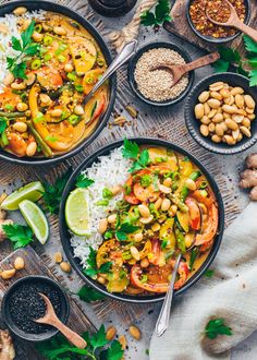 two bowls filled with rice, beans and vegetables next to spoons on a table