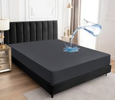 a bed with a black headboard and blue water pouring out of the top mattress