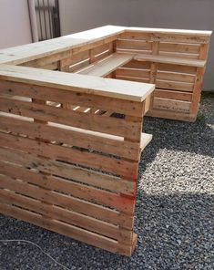 two wooden pallets sitting next to each other on top of a gravel covered ground