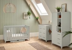 a baby's room with a crib, dresser and chest of drawers in it