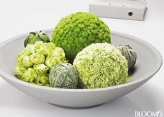 a white bowl filled with green vegetables next to a video game controller on a table