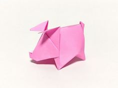 a pink origami pig on a white background