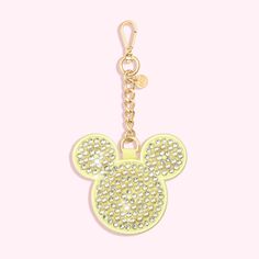 a yellow mickey mouse keychain on a pink background