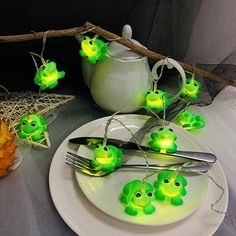 green frog string lights sitting on top of a white plate