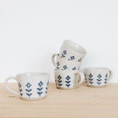 four cups and two saucers on a wooden table