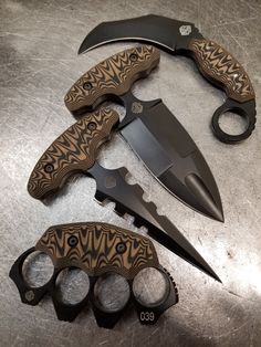 three different types of knifes and knives on top of a table with black handles