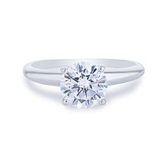 a white gold engagement ring with a round brilliant cut diamond in the center, on a plain surface