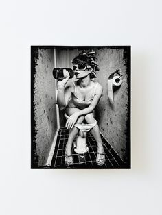 a black and white photo of a woman sitting on a toilet with her head down