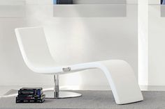 a white chair sitting on top of a carpeted floor next to a book shelf