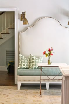 a living room with a couch, table and flowers on the coffee table in front of it