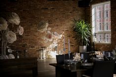 a dining room with brick walls and flowers on the wall