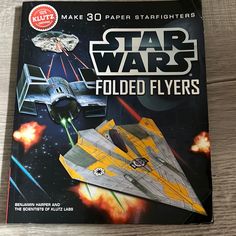 the star wars folded flyers are in front of an image of a fighter jet and a space ship