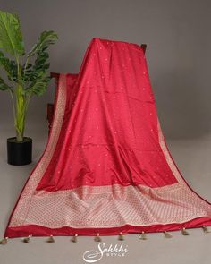 Cherry red charm abounds in the mashru silk tanchoi Banarasi, its dainty zari polkas twinkling like secret kisses across the fabric. The zari border and pallu shimmer with subtle sophistication, as the tonal blouse's soft sheen complements the saree's lively drape. This vibrant ensemble is a celebration of joy, weaving playfulness and elegance into every thread, draping the wearer in a delightful, whimsical glow. * Banarasi katan silk saree for special occasions. * Crafted from the premium quality fabric. * Supplied with a readymade blouse. * The blouse comes with an added allowance, and it can be altered to a standard size of 34"-42" on request. * Dry clean only to maintain colour and quality. Note: Colors may slightly vary due to photographic lighting. We provide same day shipping for or Banarasi Katan Silk Saree, Red Charm, Katan Silk Saree, Katan Silk, Readymade Blouse, Saree With Blouse, Photographic Lighting, Cherry Red, Dress Clothes For Women