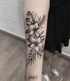 a black and white photo of a woman's arm with a flower tattoo on it