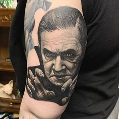 a man's arm with a portrait of an old man holding his hands to his face