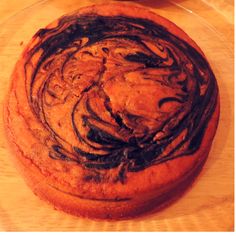 a cake sitting on top of a wooden table next to a plate with a fork