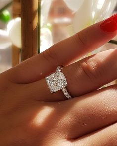 a woman's hand with a diamond ring on it