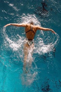 a woman is swimming in the blue water