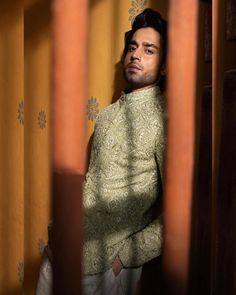 a man standing in front of a yellow curtain