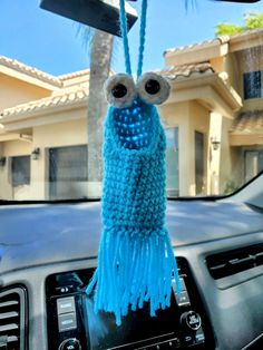 a stuffed animal hanging from the dashboard of a car