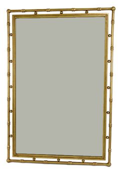 a gold framed mirror sitting on top of a white wall