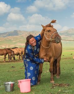 a woman is petting a brown horse