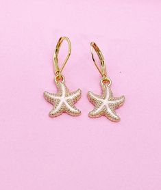 These are gold-toned starfish charms with stainless steel ear hooks. ♥ You will get one pair. HOW TO ORDER 1) Choose the quantity. 2) Add to the cart DESCRIPTION ♥ Stainless Steel Earring, Size: about 12mm wide, 14.5mm long ♥ Starfish, Alloy Enamel Pendants, Light Gold, Size: about 18mm long, 15mm wide, 3mm thick, ♥ Materials sourced from the USA and internationally, Made and shipped from Gowen, Michigan. GIFT READY: ♥ No invoice will be included in the package unless you request it. You will re Gold Starfish Earrings Nickel Free, Gold Nickel-free Starfish Earrings, Nickel-free Gold Starfish Earrings, White Starfish Charm Earrings For Gift, White Starfish Charm Earrings As Gift, White Starfish Charm Earrings, Gold Starfish Charm Drop Earrings, White Starfish Charm Star Earrings, Starfish Charm Hoop Earrings As Gift