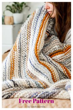 a woman wrapped in a multicolored blanket