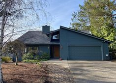 a blue house with trees in the background