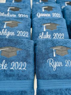 blue towels with graduation caps and tassels are lined up on a table in front of each other