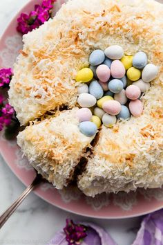 a cake on a pink plate with white frosting and candies in the middle