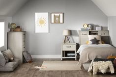 a bedroom with gray walls and wooden floors, white furniture and pictures on the wall