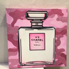 a painting of a pink and white chanel perfume bottle on a pink camo background