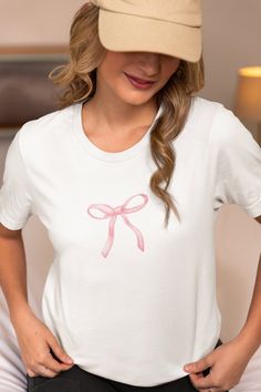 * Add a touch of sweetness to your wardrobe with this adorable pink bow t-shirt! This women's t-shirt features a charming pink bow printed design that is both cute and stylish. Made from high-quality materials, this top is perfect for adding a pop of color to any outfit. Whether you're heading out for a casual day out or just want to add a fun element to your look, this sweet pink bow t-shirt is sure to become a favorite in your collection. * Available in Multiple Sizes: Our T-Shirt comes in a r Pink Cotton T-shirt As Gift, Pink Short Sleeve Top As A Gift, Cute Pink Tops For Gifts, Cute Pink Top As Gift, Cute Pink Tops For Gift, Pink T-shirt For Summer Gift, Pink Crew Neck T-shirt As Gift, Casual Pink Top For Gift, Pink Summer T-shirt For Gift