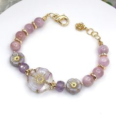 This beautiful bracelet has AAA-grade 8mm Kunzite & Lavender Amethyst Gemstones with Czech Glass flower beads as the focal in the bracelet. There is a mixture of gold-plated and gold-filled decorative beads and accents. For a complete description of all that is in this bracelet, I have a listing of this below. This bracelet is 7 inches to 7.5 inches long with the added extender jump rings. This bracelet comes with a jewelry gift box, polishing cloth, and a pamphlet with information on Kunzite an Gold Amethyst Jewelry With 8mm Beads, Lavender Bracelets With Spacer Beads As Gift, Lavender Bracelets With Spacer Beads For Gift, Pink Hand-strung Amethyst Jewelry, Amethyst Beaded Bracelets With Spacer Beads As Gift, Gold Amethyst Beaded Bracelets, Elegant Lavender Beaded Bracelet For Healing, Amethyst Spacer Beads Jewelry, Lavender Bracelet With Spacer And Round Beads